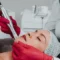 Woman receiving facial microneedling from a clinician in red gloves in Greenville, SC